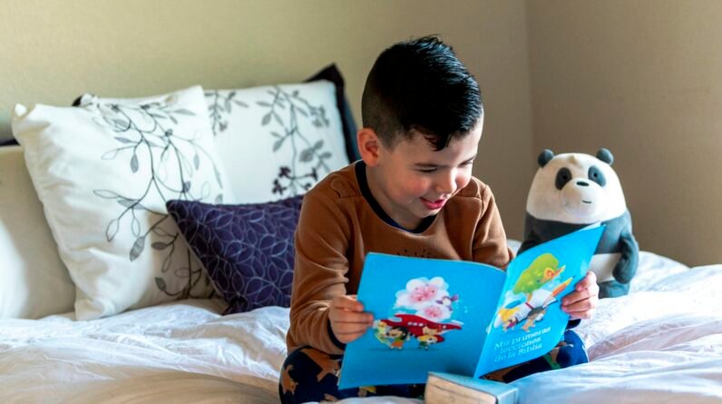 Young child exploring an illustrated picture book while practising early reading skills.